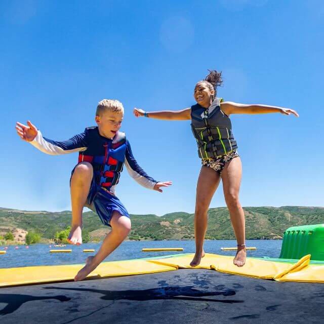 Two kids jumping on water